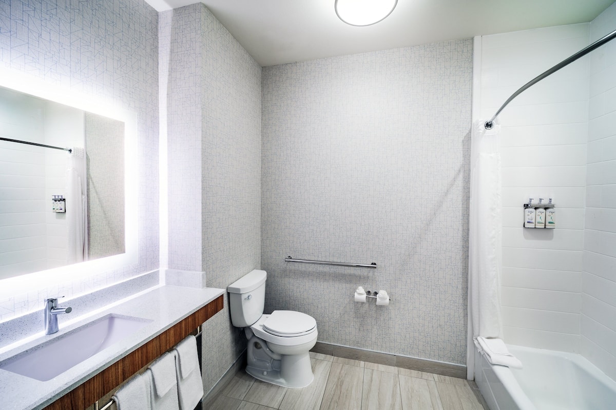 A modern bathroom with a toilet, sink, and shower.