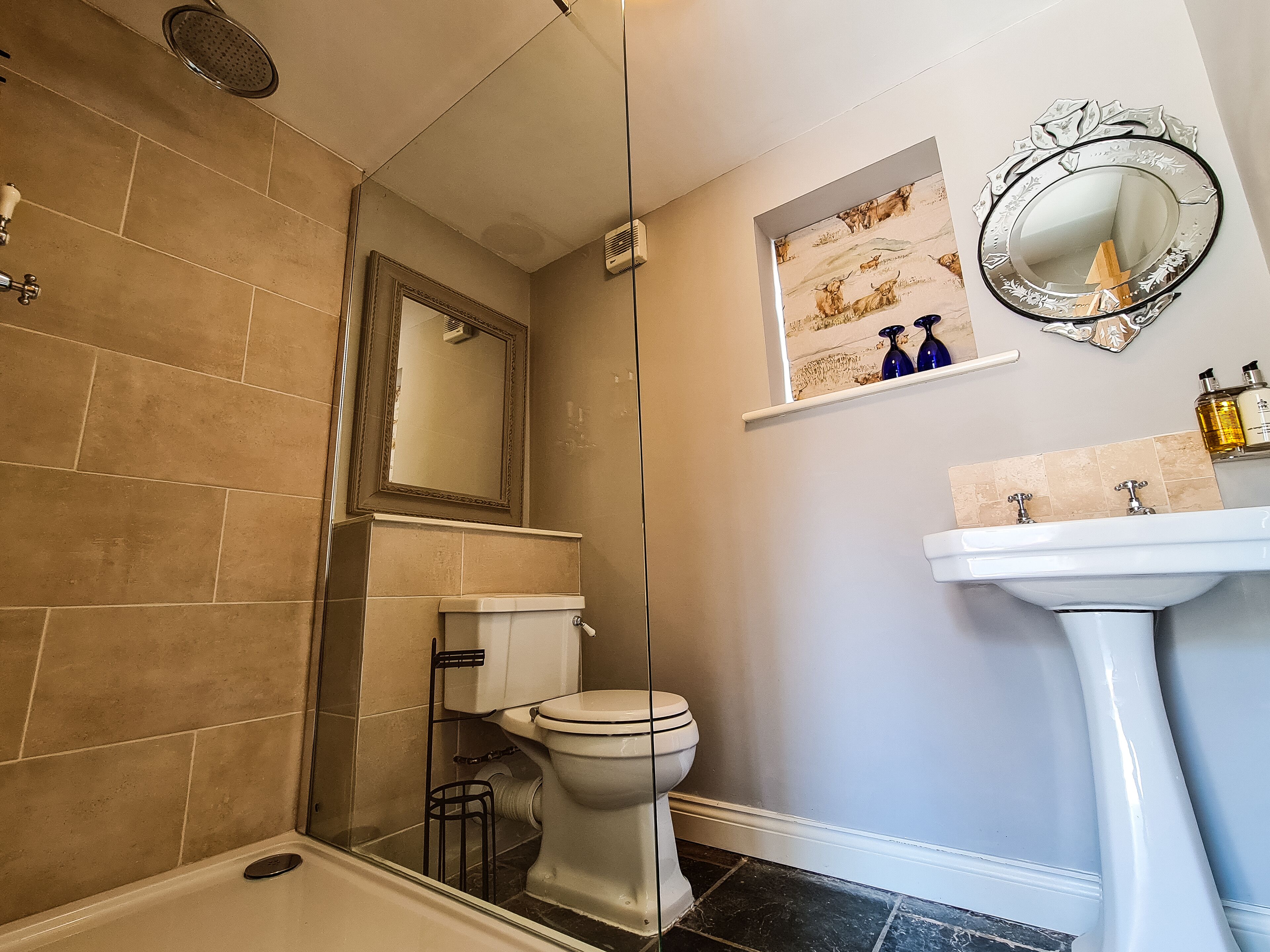 A bathroom with a bathtub, toilet, sink, and a shower area.