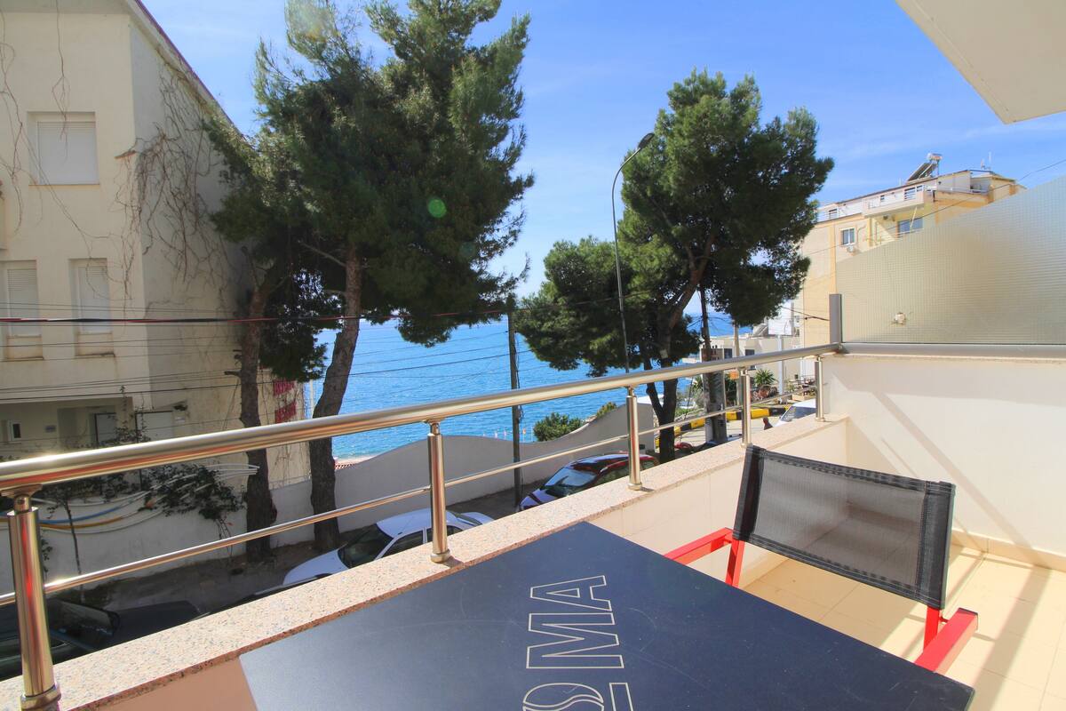 A balcony with a railing, a table, and chairs.