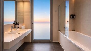 Un baño moderno con un ventanal grande, una bañera y un tocador con espejo.