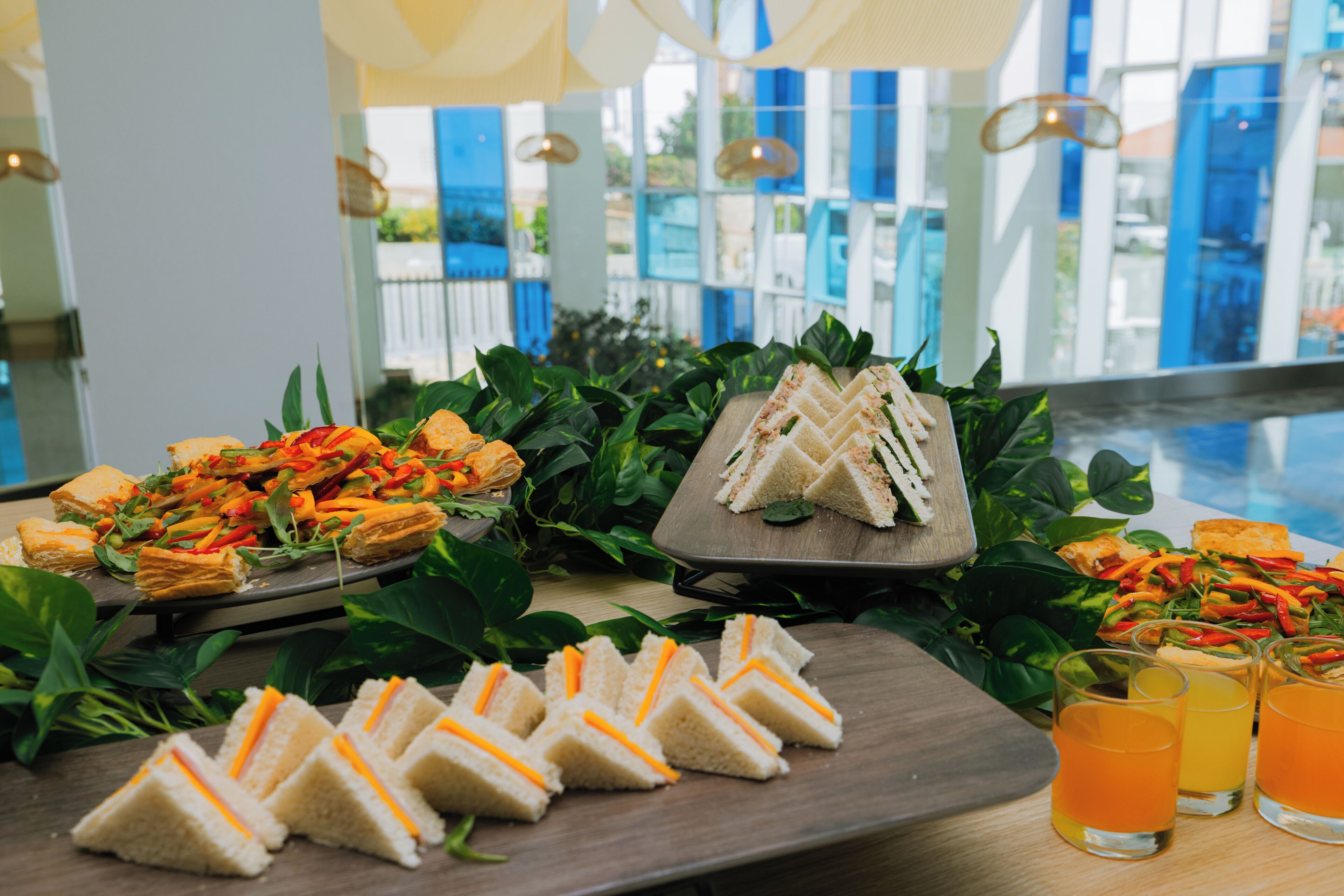 Een buffet met belegde broodjes, salades en drankjes.
