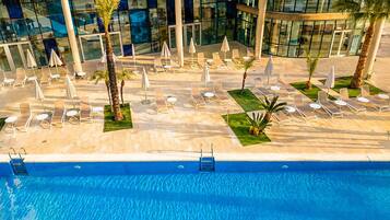 Una piscina cubierta, una piscina al aire libre de temporada, tumbonas