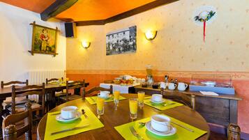 A dining area with wooden tables, chairs, and a buffet setup.
