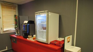Un petit coin cuisine équipé d’une machine à café, d’un réfrigérateur et d’un four à micro-ondes.