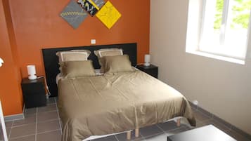 A bedroom with a bed, two bedside tables, and a window.