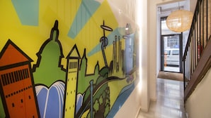 A colorful mural with architectural and musical elements on a hallway wall. - Happy People Plaza España (Barcelona)