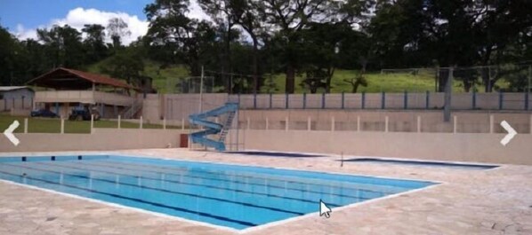 Una piscina con carriles delimitados, una escalera y una valla.