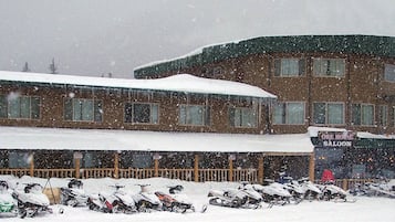 Lumipeitteinen rakennus, jonka katolla on kyltti, jossa lukee ”Soda Butte Lodge” ja sen alla pienemmällä tekstillä ”Tavern & Casino”.
