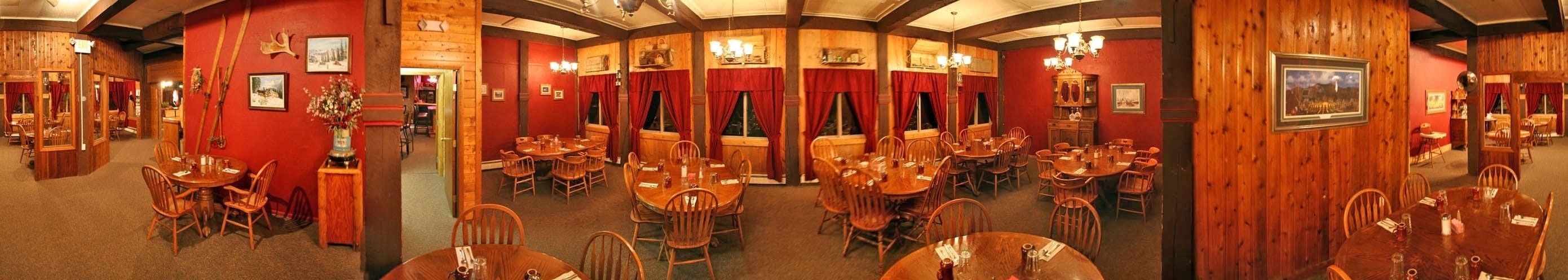 A restaurant with multiple dining areas, wooden walls, and red curtains.