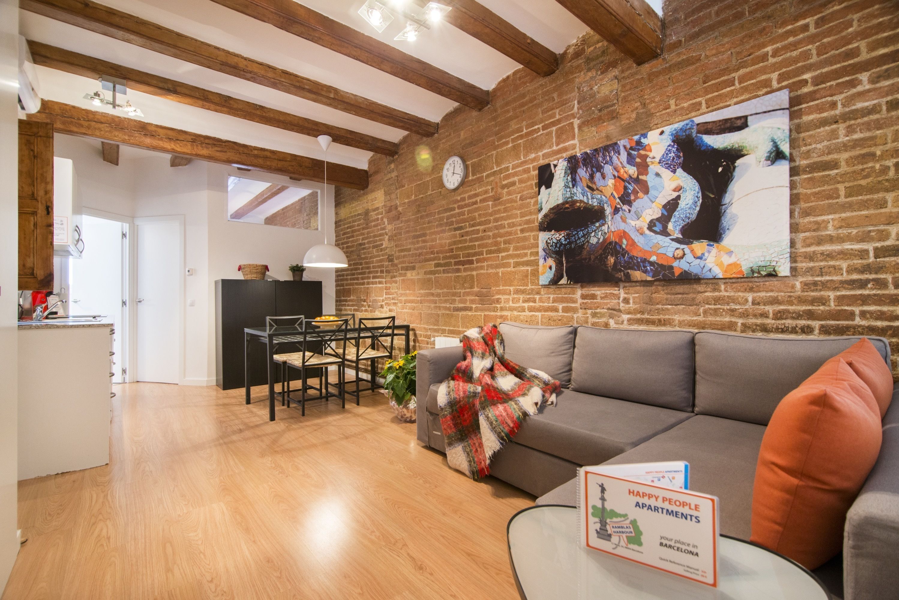 A cozy living area with a wooden ceiling, a dining table, and a sofa.