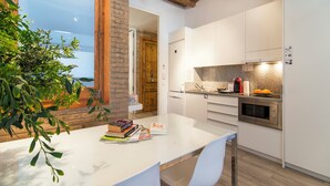 A modern kitchen with white cabinets, a granite countertop, and a built-in oven.