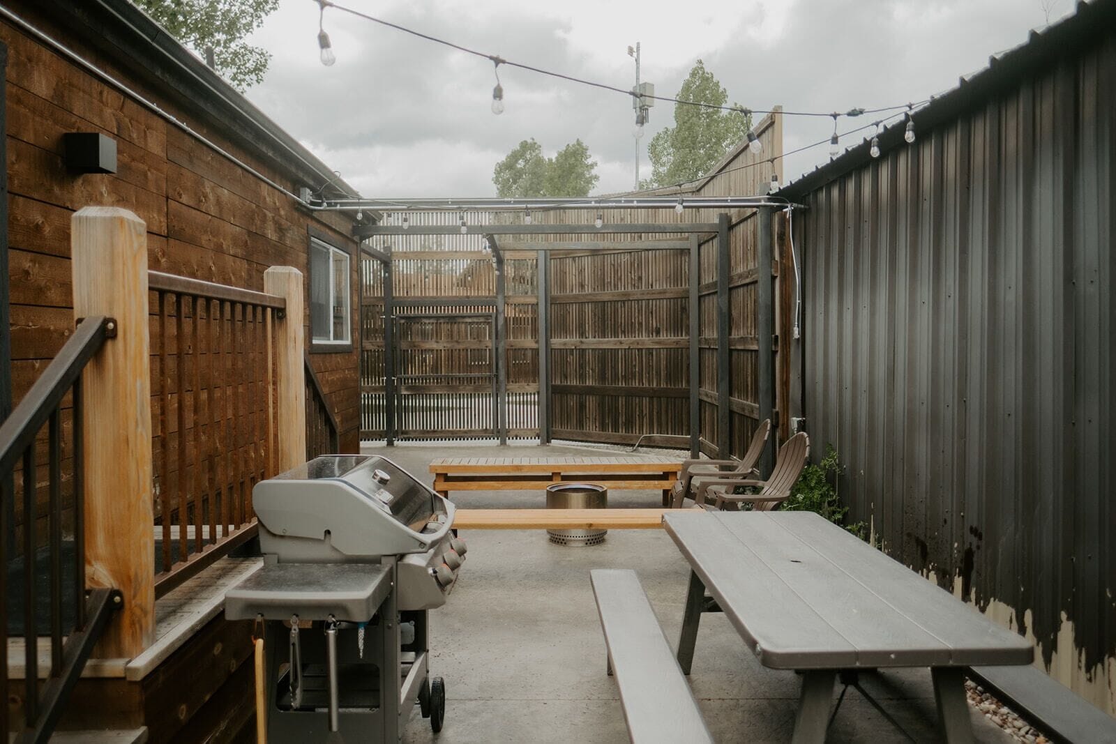 A backyard with a barbecue grill, picnic table, and outdoor seating area.