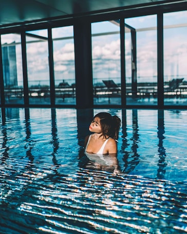 Una piscina techada, sillones reclinables de piscina