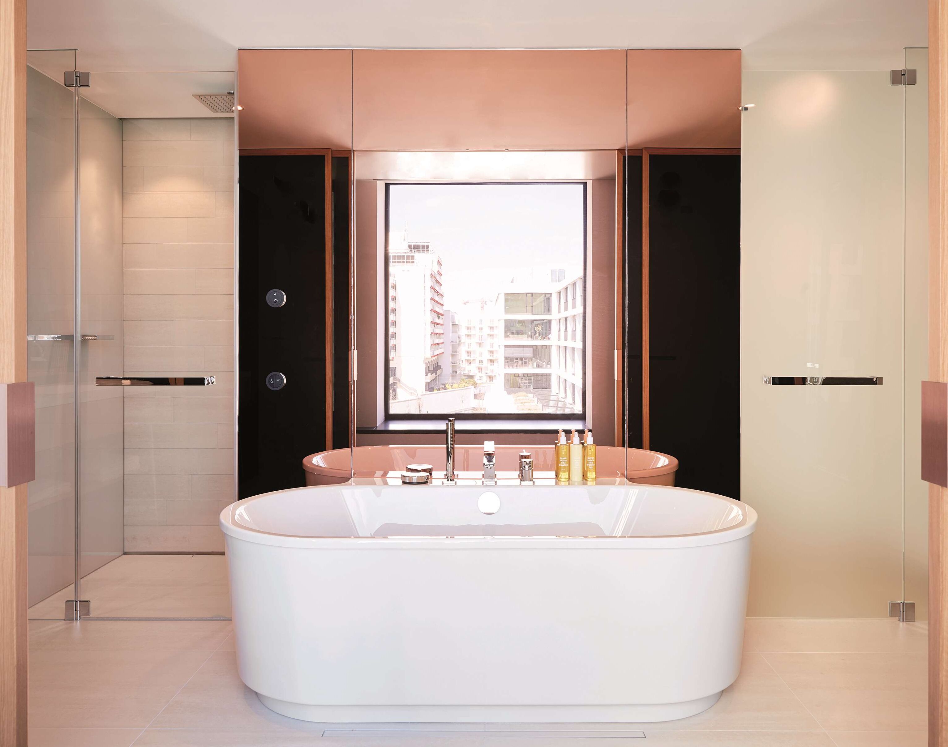 Een moderne badkamer met een vrijstaand bad, een groot raam met uitzicht over de stad, en een minimalistisch design.