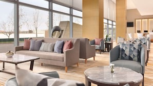 A modern hotel lobby with a large seating area, including sofas and armchairs, a coffee table, and a reception desk. - Hyatt Place Beijing DaXing (Beijing)