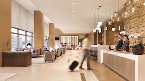 A modern hotel lobby with a reception desk, seating area, and large windows. - Hyatt Place Beijing DaXing (Beijing)