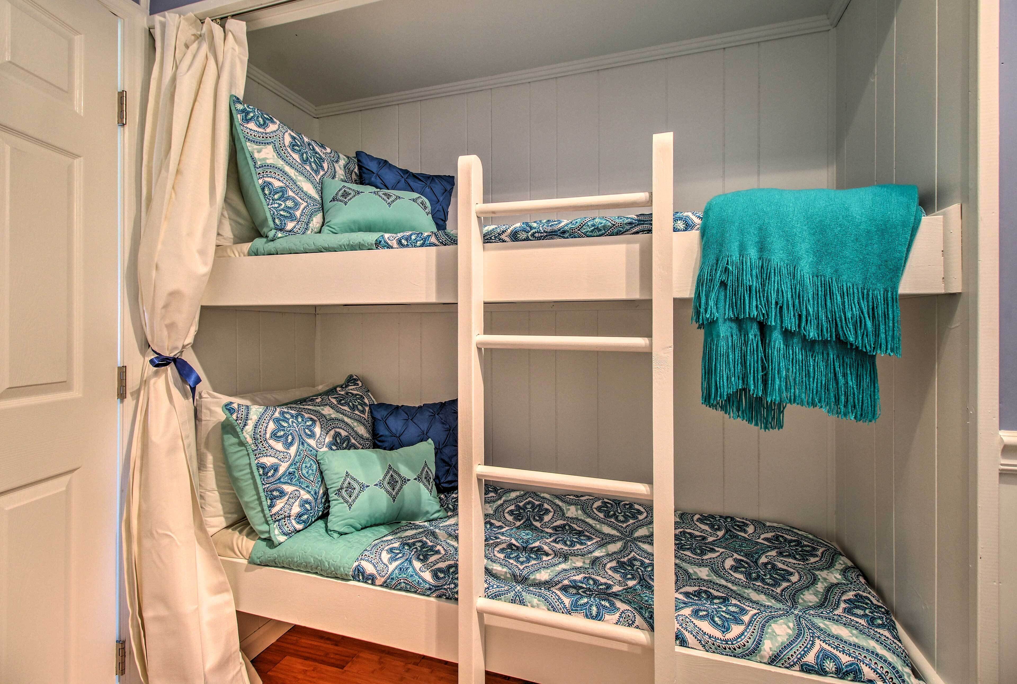 Una litera con ropa de cama estampada y una manta color turquesa.