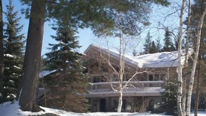 Un edificio grande de varios pisos rodeado de árboles altos y cubierto de nieve.