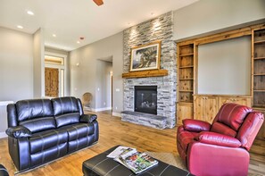 A living room with a stone fireplace, leather sofas, and a wooden cabinet.