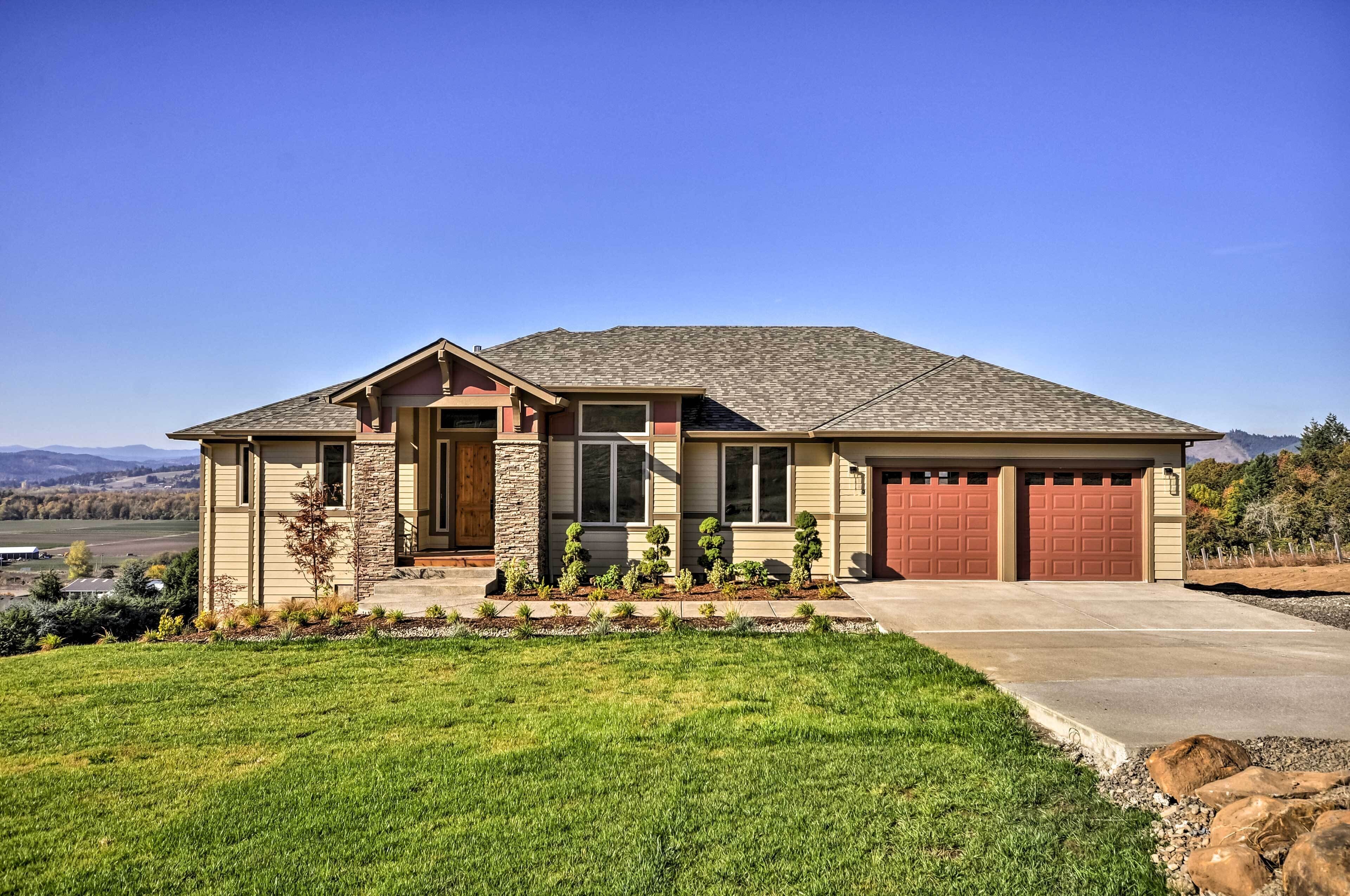 Ein einstöckiges Haus mit einer Steinaußenwand, einer Veranda und einer Garage.