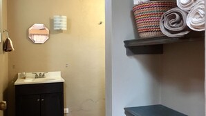 A bathroom with a sink, mirror, towel rack, and a shelf with rolled towels. - LOveFT The place to be t Valle de Bravo (Valle de Bravo)