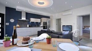 Ein modernes Wohnzimmer mit Essbereich, Küche und Schlafzimmer.