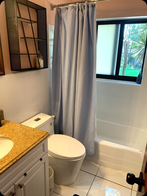 Une salle de bain avec des toilettes, un lavabo et une baignoire.