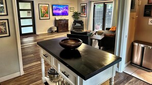 Una cocina moderna con una isla central, suelo de madera y estufa empotrada.