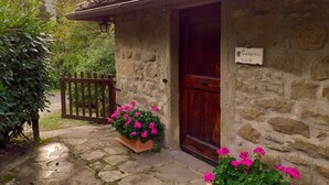 A stone building with a wooden door and a sign that reads "Casacola Veste 10".
