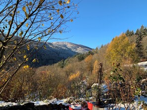 Eine gebirgige Landschaft mit einer Steinmauer und Topfpflanzen im Vordergrund.