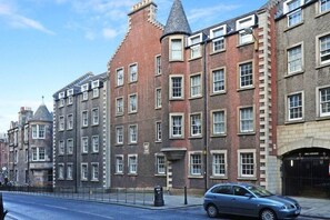 A row of traditional brick buildings with uniform window patterns and a central tower. - Vibrant Edinburgh Flat with Private Entrance (Edinburgh)