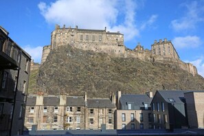 A historic castle on a hill with modern buildings in the foreground. - Bohemian Writers Retreat in Old Town (Edinburgh)