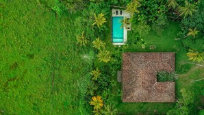 An aerial view of a property with a swimming pool, a thatched-roof building, and surrounding lush greenery. - Beautiful Staffed 5 Bedroom Villa, Very Personal Touch Overlooking Paddy Fields (Pitiduwa in Talpe Pattuwa)