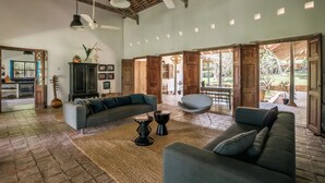 A spacious living area with a high ceiling, wooden beams, and large windows. - Beautiful Staffed 5 Bedroom Villa, Very Personal Touch Overlooking Paddy Fields (Pitiduwa in Talpe Pattuwa)
