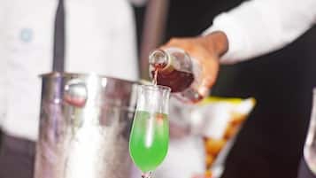 A bartender pouring a drink into a glass.