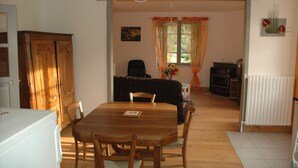 Ein Essbereich mit Holztisch und -stühlen, einer Couch und einer Heizung.