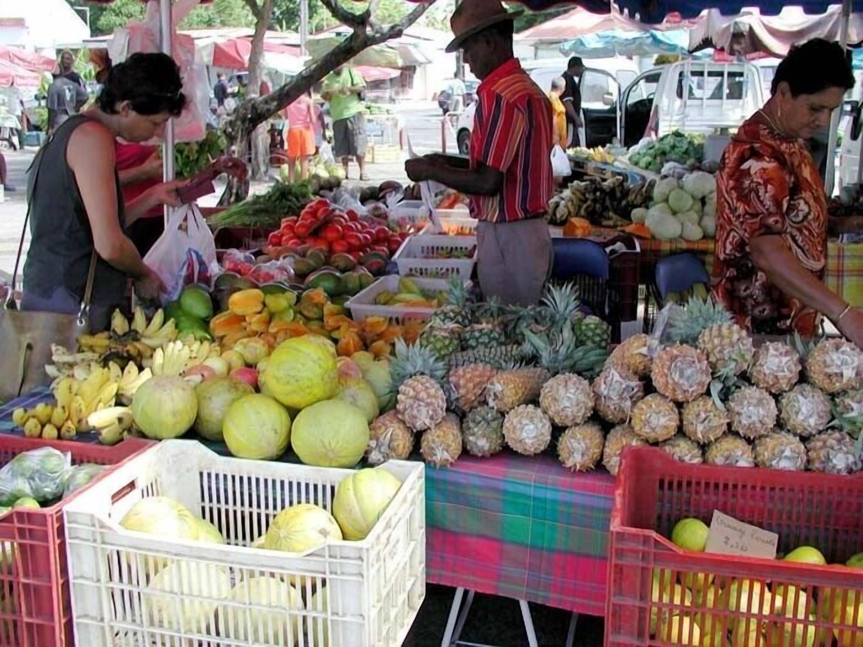 A fruit market with various fruits displayed in crates and baskets.