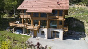 A two-story wooden house with a red-tiled roof, large windows, and a balcony. - La Marcairie Grand Chalet - Spa Luxury 5 stars (Muhlbach-Sur-Munster)
