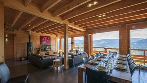 A spacious room with a fireplace, a television, and a dining area with a table set for six. - La Marcairie Grand Chalet - Spa Luxury 5 stars (Muhlbach-Sur-Munster)