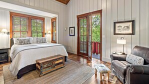 A bedroom with a bed, bedside tables, a bench, a sofa, and a door leading to a balcony. - Owl's Nest - 2/2.5, Luxurious, Pet Friendly Home (Black Mountain)
