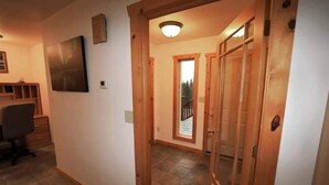 A hallway with wooden doors, a tiled floor, and a desk with a chair. - 3 Bedroom Home with Amazing Views 11 mi from Denal (Healy)
