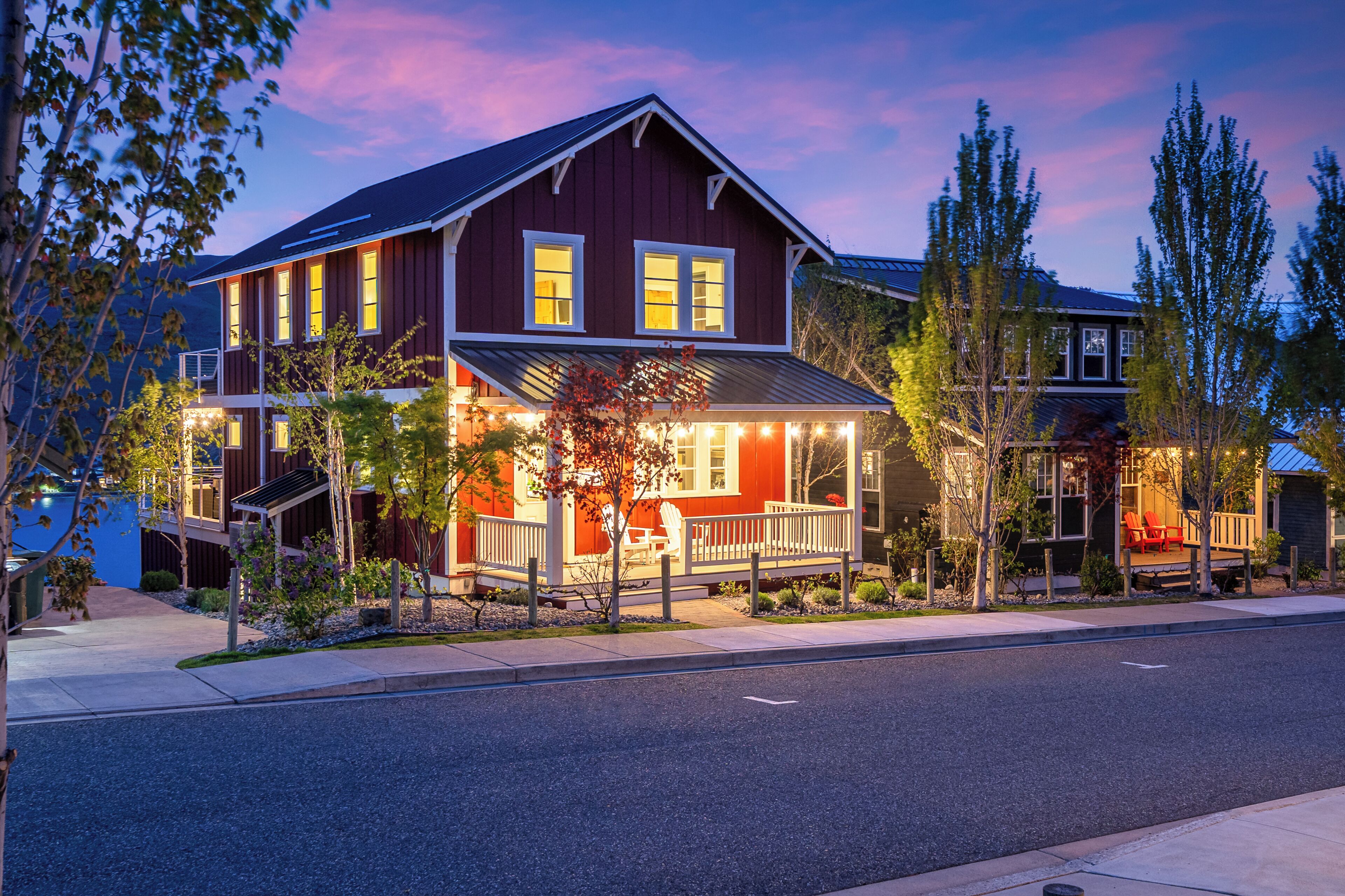 A two-story house with a porch, a covered front entrance, and a small deck.