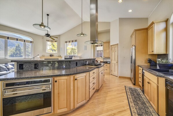 Prepare meals in the spacious kitchen with a large island, oven, and microwave.