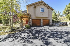 A two-story house with a covered porch, stone foundation, and two garage doors. - Magnificent 4 Bedroom Home in the Reserve in Frisco (Frisco)