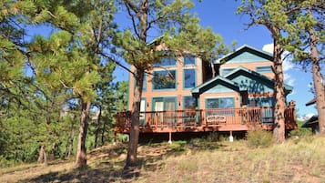 Guests can enjoy scenic views from the upper level's large windows and relax on the outdoor deck with a railing.