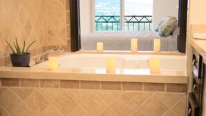 Une salle de bain avec une baignoire, un lavabo et une plante en pot.