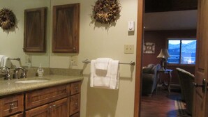 A bathroom with wooden cabinets, a sink, and a towel rack. - Buttes Condo, Steps from the base area, Mountain Luxury (Crested Butte)