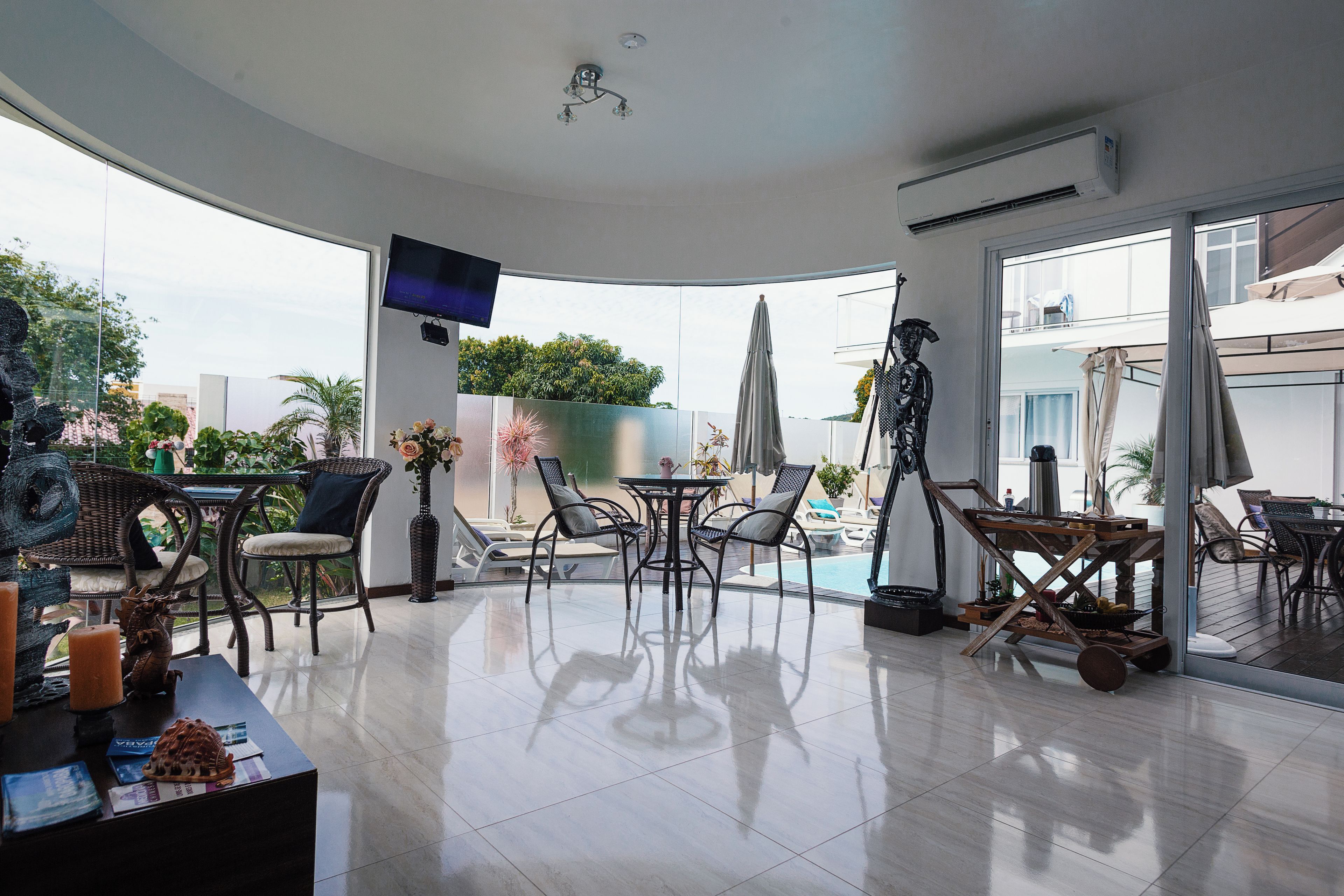 A modern living room with a flat-screen TV, a pool table, and outdoor seating.