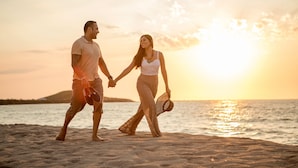 A couple holding hands on a beach at sunset. - Diamond Bay (Mazatlán)