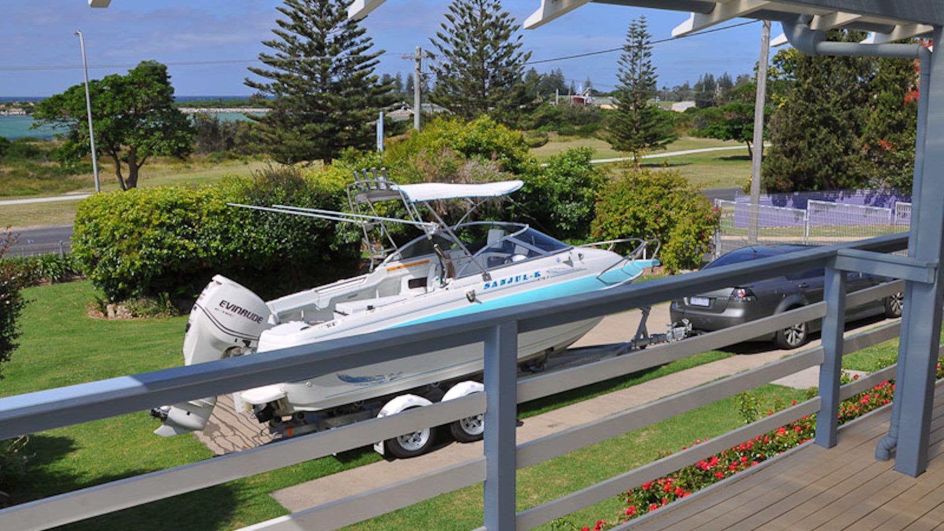 A boat parked on a wooden deck with a view of a coastal area.